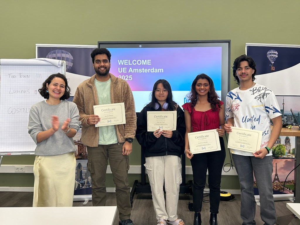 Students holding certificates at event hosted at UE Amsterdam